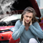 Women holding her neck in pain after a car accident