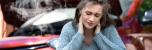 Women holding her neck in pain after a car accident