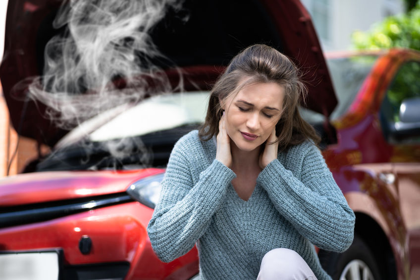 Women holding her neck in pain after a car accident